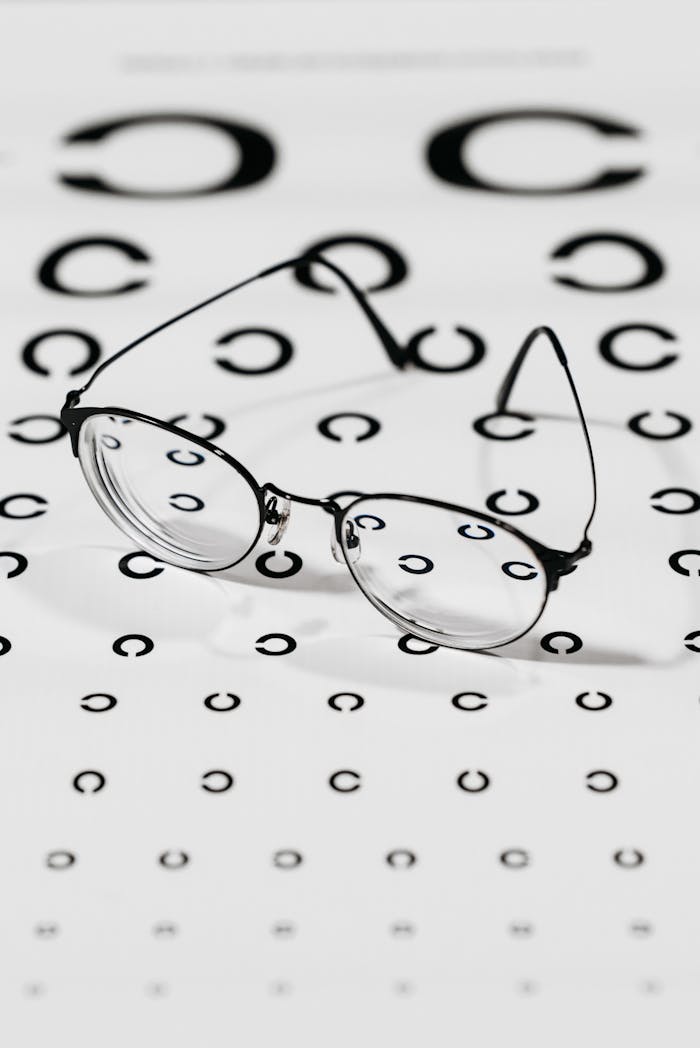 Eyeglasses resting on a Snellen eye test chart emphasizing vision correction and eye care.